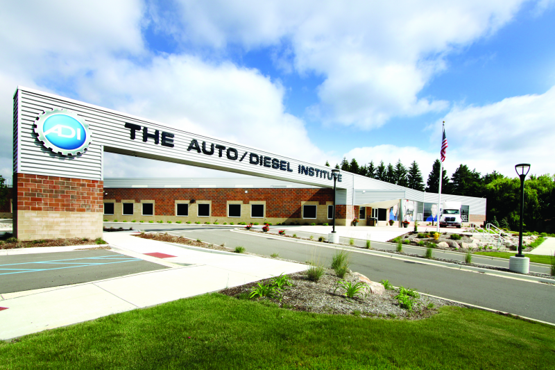 An exterior photo of the ADI campus entrance and large hanging sign